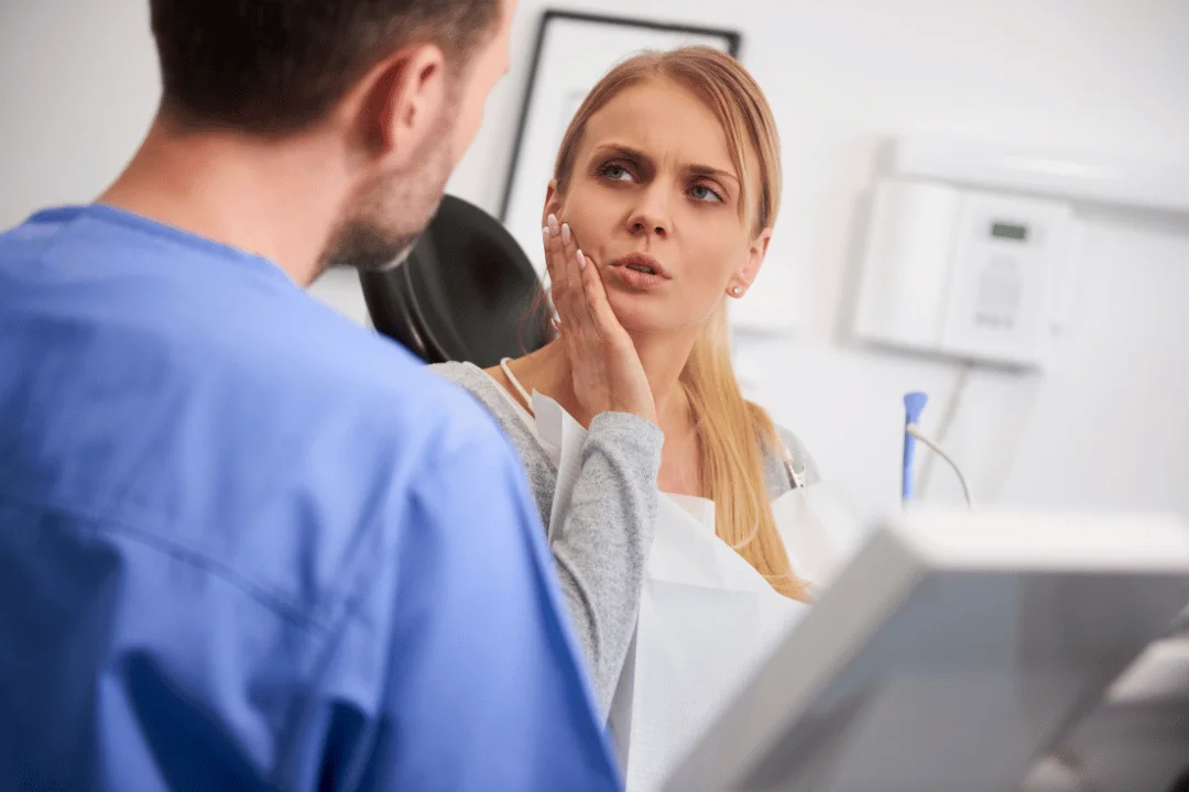 Patient expressing concern about tooth pain during consultation with dentist at Crown Dental Care in Rockville.