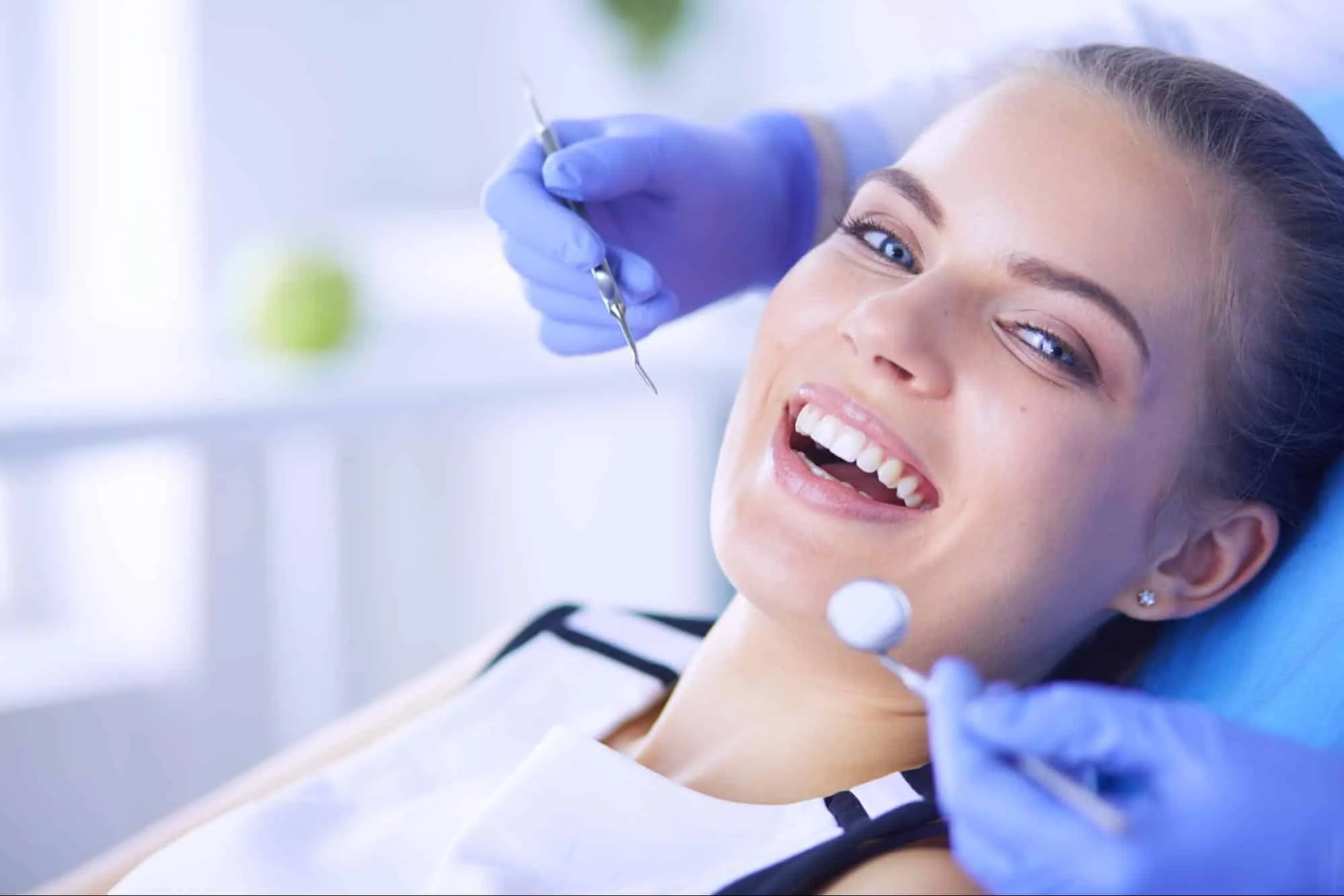 A happy young woman receiving a routine dental inspection